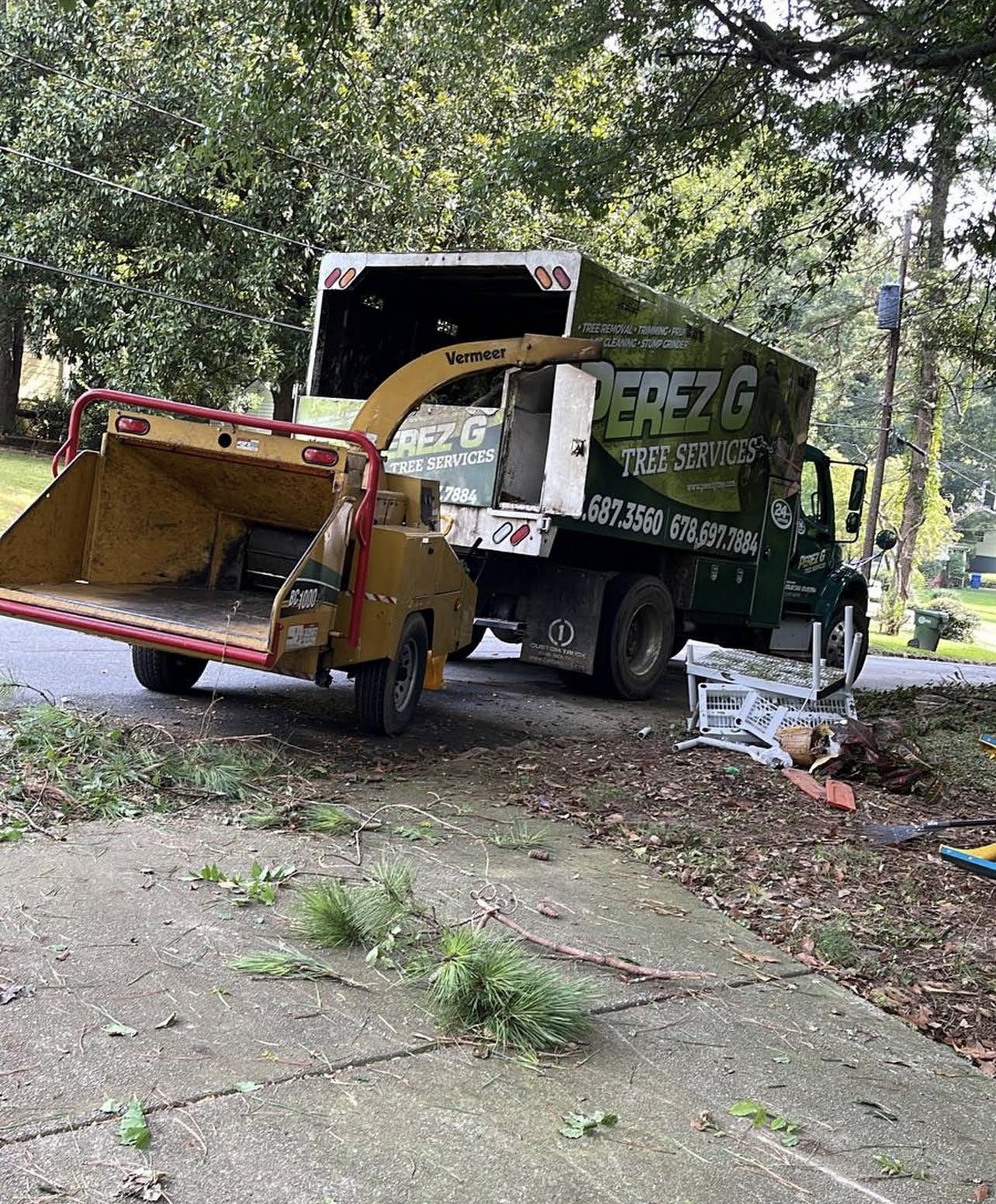 Perez G Tree Services dump truck with Vermeer wood chipper parked at a residential job site
